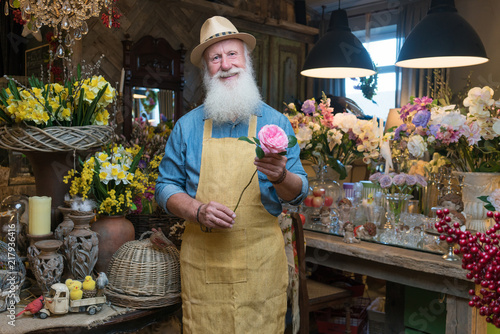 Fototapet Old man with beard, florist taking care of flowers in flower shop