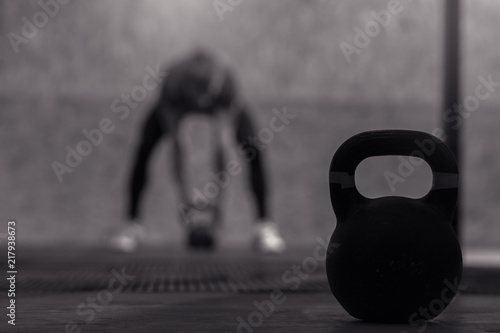 Fototapeta Naklejka Na Ścianę i Meble -  Athletic young man working out in gym. Muscular male adult exercising with kettle bells, functional or cross training. Fitness and sports concept.