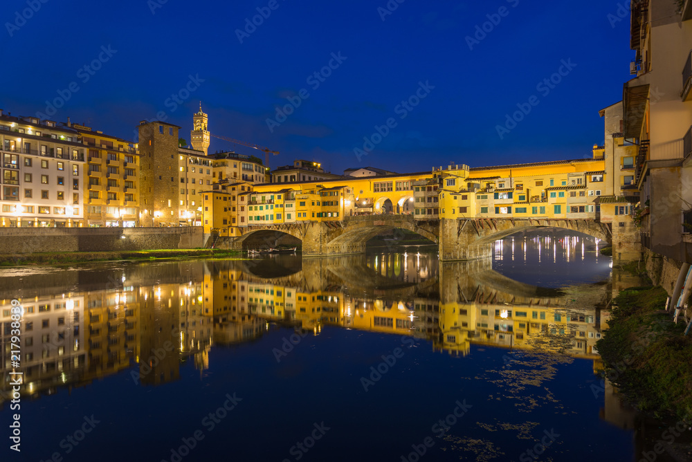 Night riverside scenery of Arno river, Tuscany architectures style and Ponte Vecchio bridge in Florence, Italy.