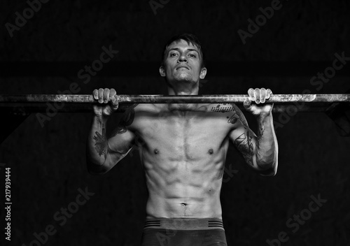 Muscular male athlete doing pull up exercise on horizontal bar. sports, fitness concept. © pavel_shishkin