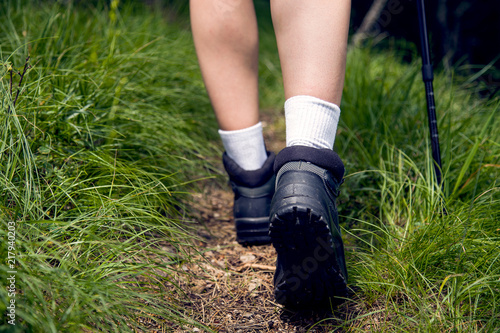 Low angle view of female hiker boots.Hiker walking in a forest