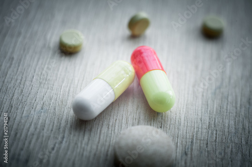 Selective focus on pill spread on wooden background with shadow. Global healthcare concept. Pharmaceutical industry.