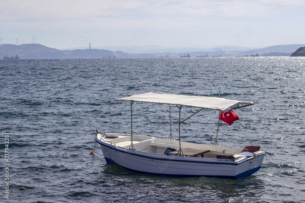 Obraz premium Perspective shot of wooden fishing boat on the sea at sunset of horizon