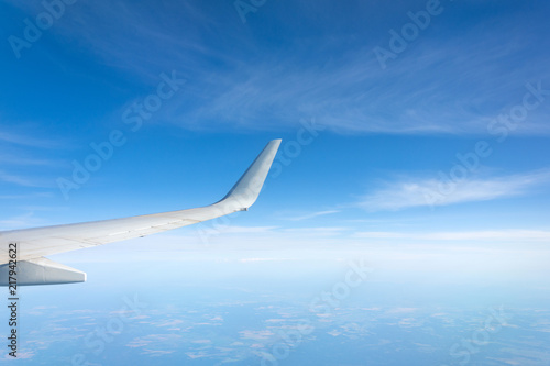 Wing view of the airplane on a winglets, clouds on the skyline during climbing flight level.