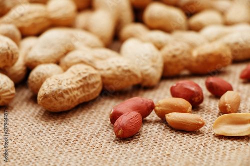 Peanuts are peeled and inshelled in the background of sackcloth.