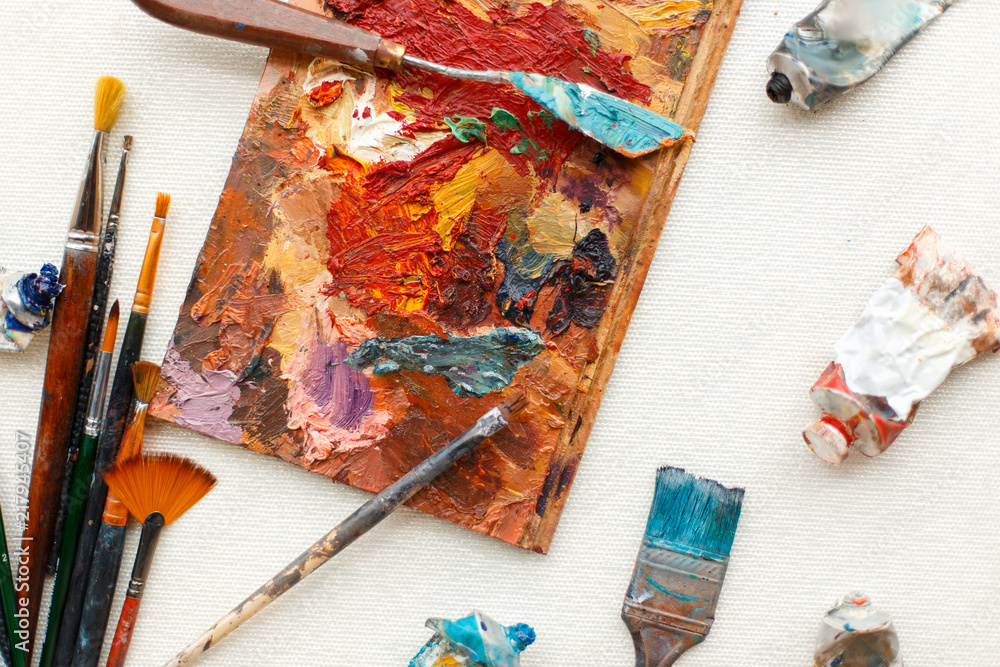 Fototapeta premium Vintage brushes with oil paint lie on the desktop. A set of tools for the artist