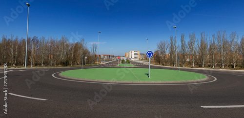 Rotonda o glorieta de reciente construccion en vista panoramica. Diseñada en cemento pintado de verde simulando cesped. En las afueras de un espacio urbano con edificios photo