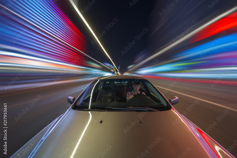 Obraz premium Blurred downtown look from fast driving car to back side and driver at summer twilight. Longexposure shot.