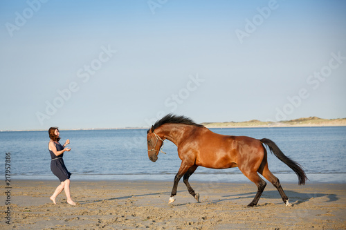 Frau mit Pferd am Meer
