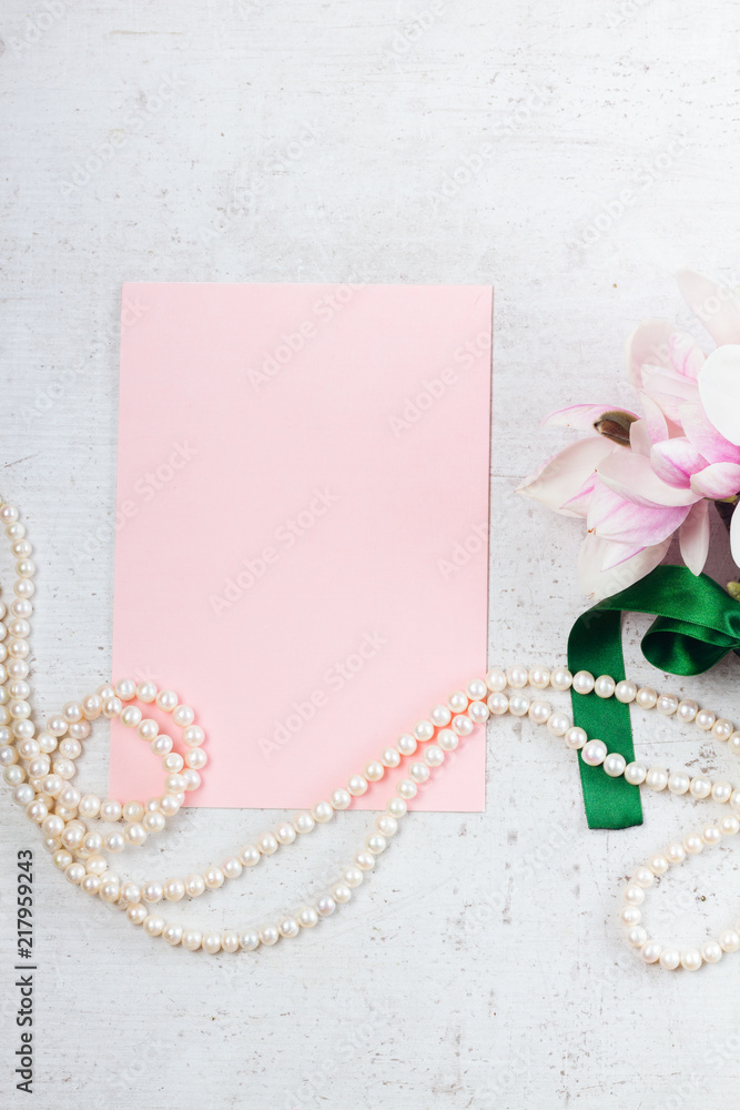 Magnolia flowers and jewellery flat lay composition with copy space on pink paper note Magnolia flowers and jewellery flat lay composition with copy space on pink paper note