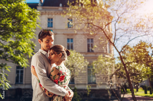 Young happy couple in love hugging outdoors. Romantic man and woman walking on city street © maryviolet