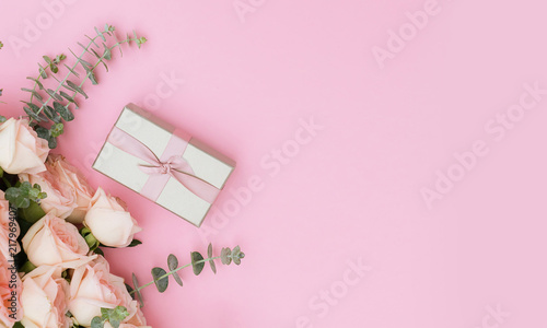 gift box and flowers on pink table from above, flat lay banner © neirfy