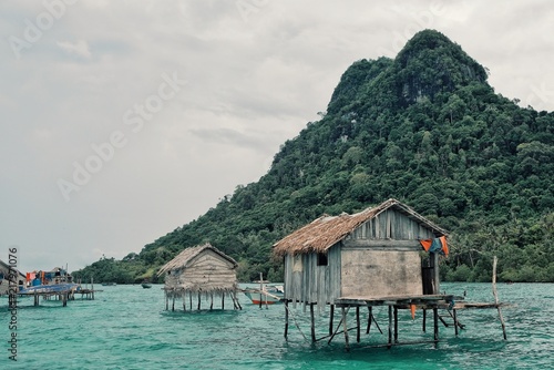 stilt houses in a bajau sea gypsy village next to a small island rock outcrop