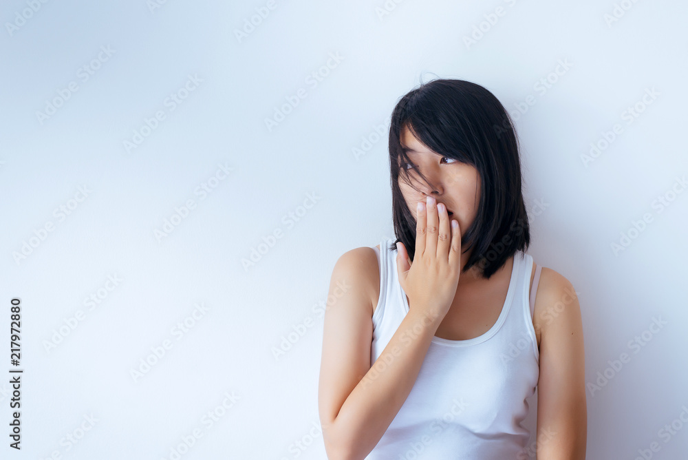 Asian woman covering her mouth and smell her breath with hands upter wake up on white blackground,Bad smell Asian woman covering her mouth and smell her breath with hands upter wake up on white blackground,Bad smell