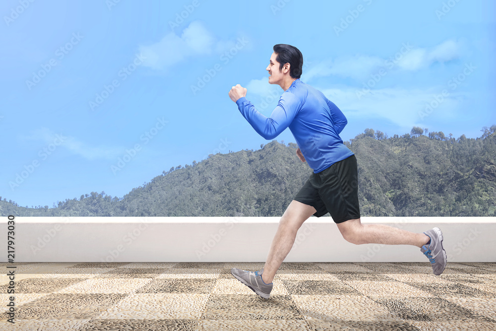 Handsome asian man running outdoors