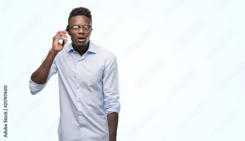 Young african american man using smartphone scared in shock with a surprise face, afraid and excited with fear expression Young african american man using smartphone scared in shock with a surprise face, afraid and excited with fear expression
