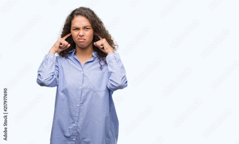 Young hispanic business woman covering ears with fingers with annoyed expression for the noise of loud music. Deaf concept.