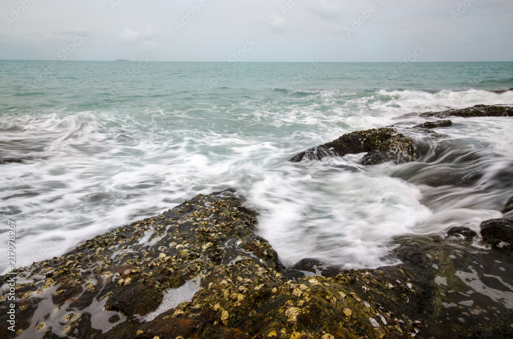 Sea waves crashing to rocks creating foam