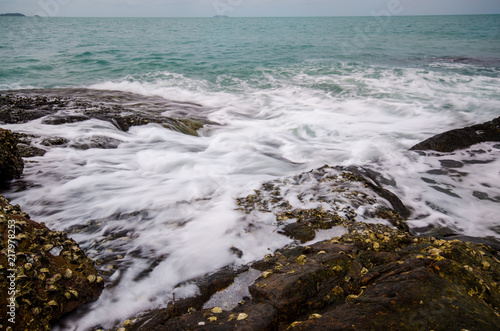 Sea waves crashing to rocks creating foam