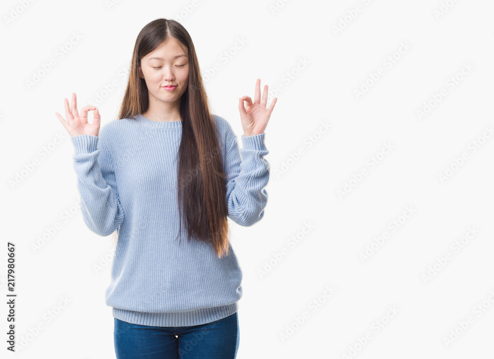 Young Chinese woman over isolated background relax and smiling with eyes closed doing meditation gesture with fingers. Yoga concept. Young Chinese woman over isolated background relax and smiling with eyes closed doing meditation gesture with fingers. Yoga concept.