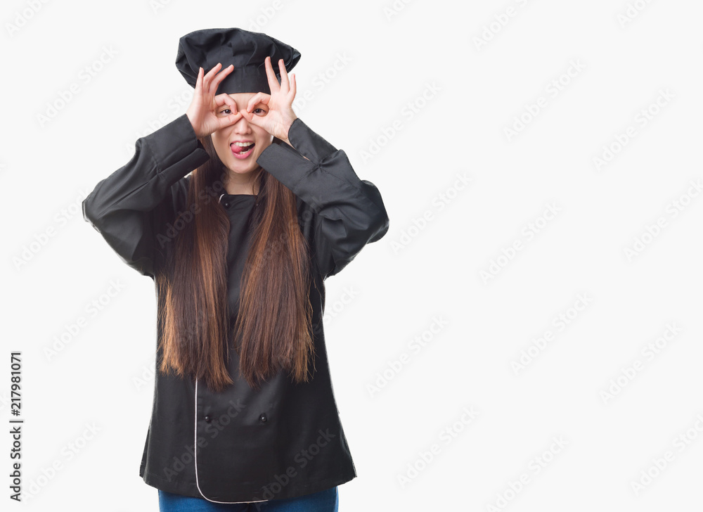 Young Chinese woman over isolated background wearing chef uniform doing ok gesture like binoculars sticking tongue out, eyes looking through fingers. Crazy expression. Young Chinese woman over isolated background wearing chef uniform doing ok gesture like binoculars sticking tongue out, eyes looking through fingers. Crazy expression.