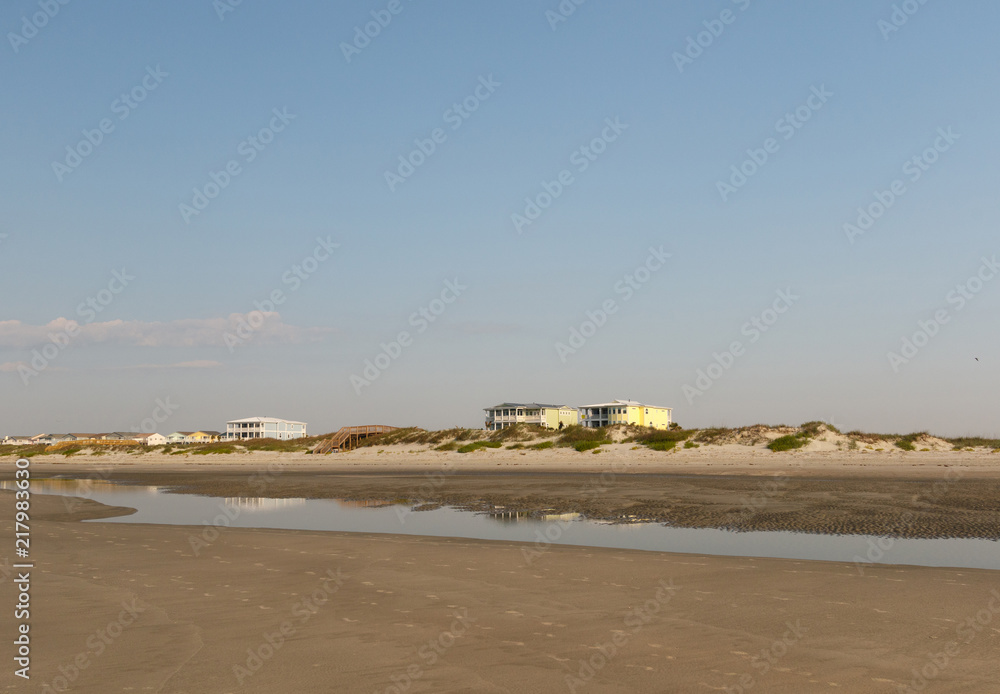 Luxury beach houses on the Atlantic Ocean, seen across an empty beach at sunrise, Sunset Beach, North Carolina Luxury beach houses on the Atlantic Ocean, seen across an empty beach at sunrise, Sunset Beach, North Carolina