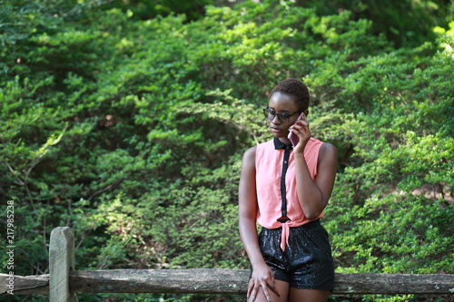 Fashionable black woman speaking on phone in park
