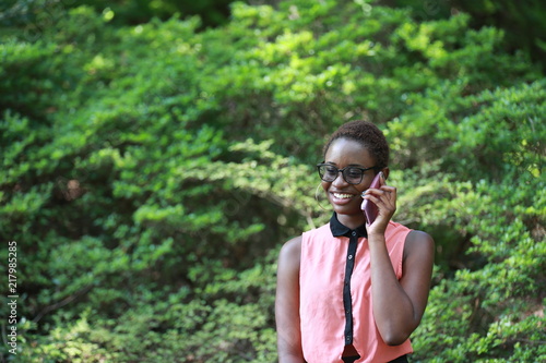 Cheerful black woman chatting via phone