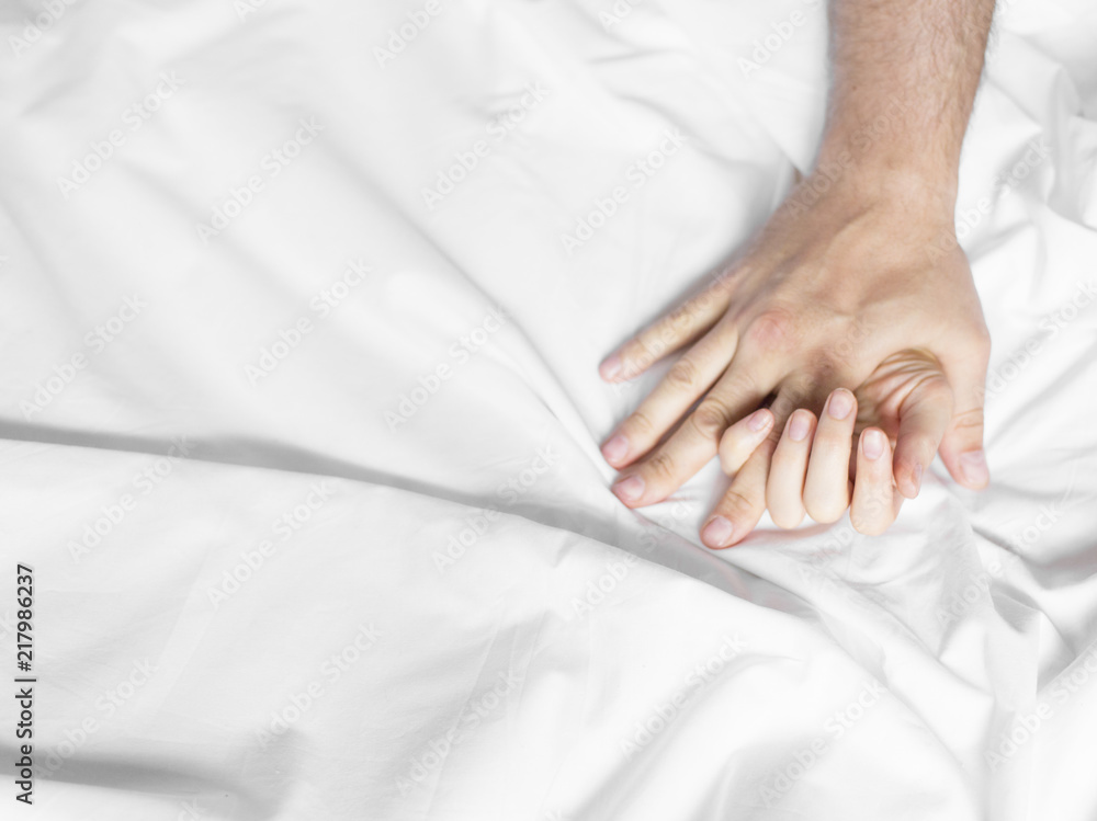 couple hands pulling white sheets in ecstasy, orgasm. Concept of passion. Orgasm. Erotic moments. Intimate concept. Sex couple. Bedroom couple hands pulling white sheets in ecstasy, orgasm. Concept of passion. Orgasm. Erotic moments. Intimate concept. Sex couple. Bedroom
