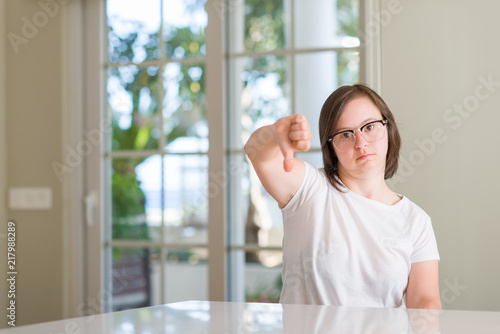 Down syndrome woman at home with angry face, negative sign showing dislike with thumbs down, rejection concept Free Download Down syndrome woman at home with angry face, negative sign showing dislike with thumbs down, rejection concept - GFXLoad
