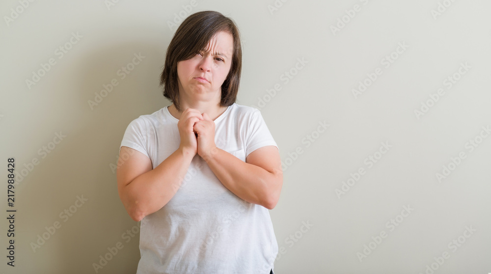 Down syndrome woman standing over wall skeptic and nervous, frowning upset because of problem. Negative person. Down syndrome woman standing over wall skeptic and nervous, frowning upset because of problem. Negative person.