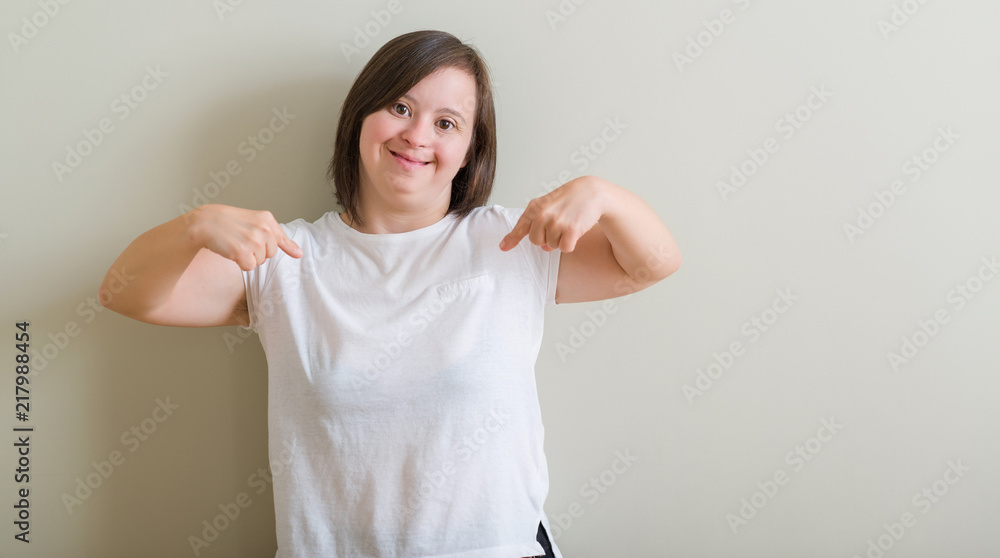 Down syndrome woman standing over wall looking confident with smile on face, pointing oneself with fingers proud and happy. Down syndrome woman standing over wall looking confident with smile on face, pointing oneself with fingers proud and happy.