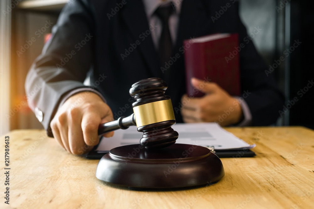 justice and law concept.Male judge in a courtroom the gavel, working with digital tablet computer on wood table in morning light justice and law concept.Male judge in a courtroom the gavel, working with digital tablet computer on wood table in morning light