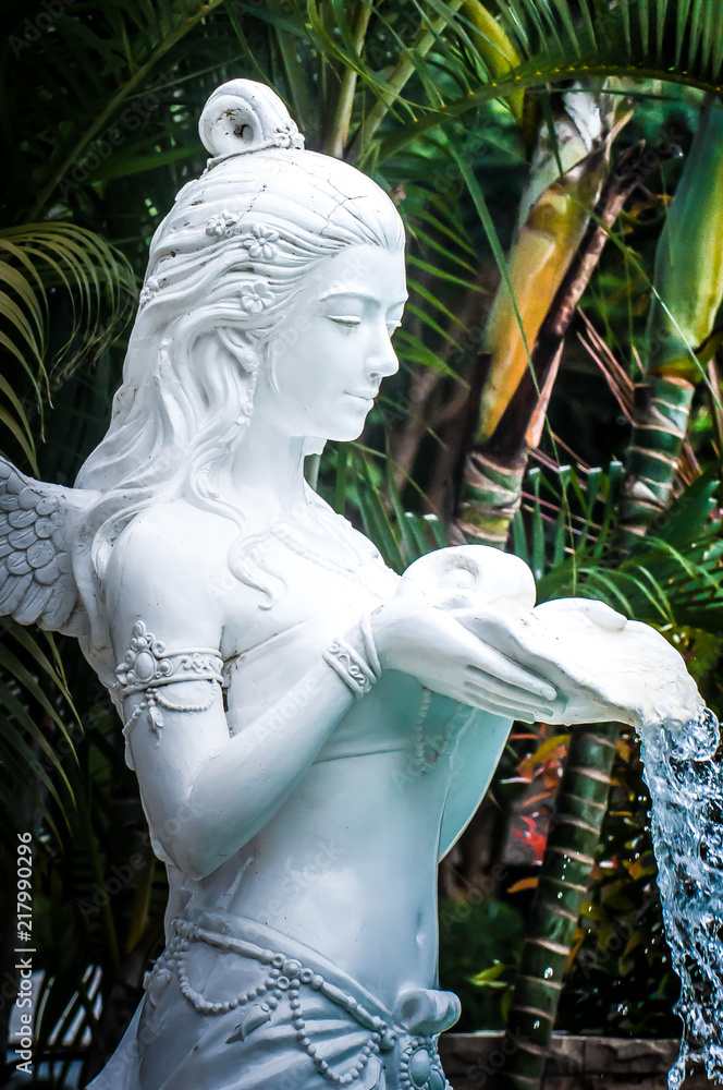 Φωτογραφία Statue of an angel with wings of white stucco on the edge of the pool water out of hand