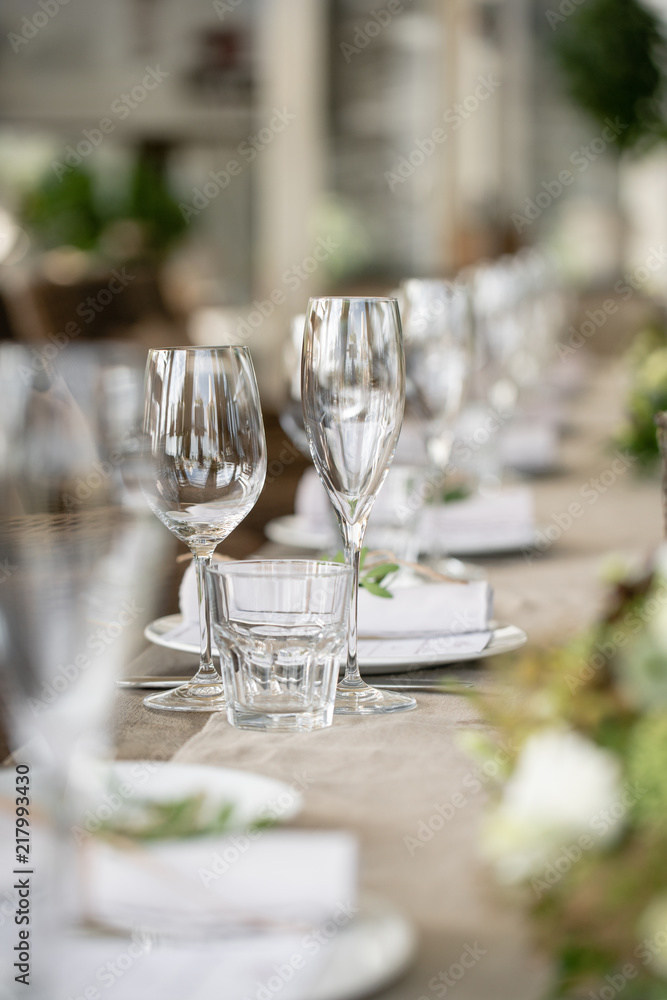 Fototapeta premium Wedding Banquet or gala dinner. The chairs and table for guests, served with cutlery and crockery. Covered with a linen tablecloth runner. party on terrace