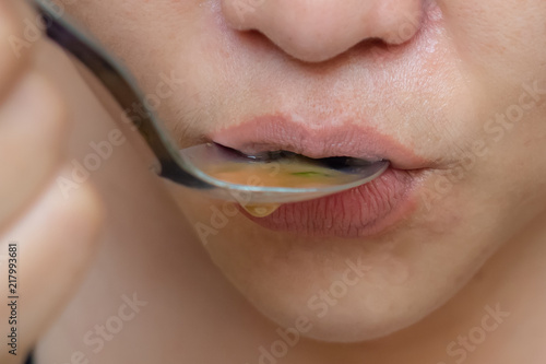 Billede på lærred Close up women take a spoonful of food into their mouths