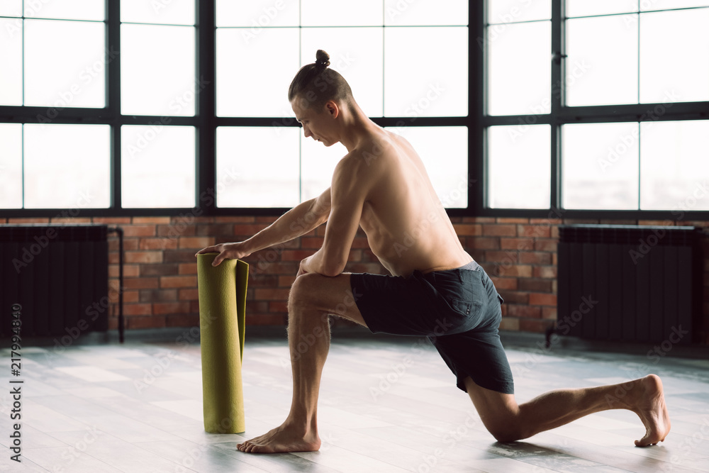 healthy and fit body. gym training. active lifestyle. man preparing to exercise on a yoga mat. healthy and fit body. gym training. active lifestyle. man preparing to exercise on a yoga mat.