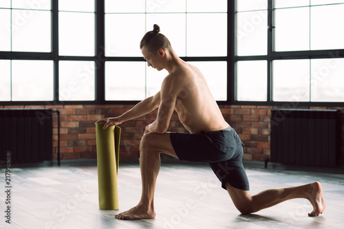 healthy and fit body. gym training. active lifestyle. man preparing to exercise on a yoga mat.