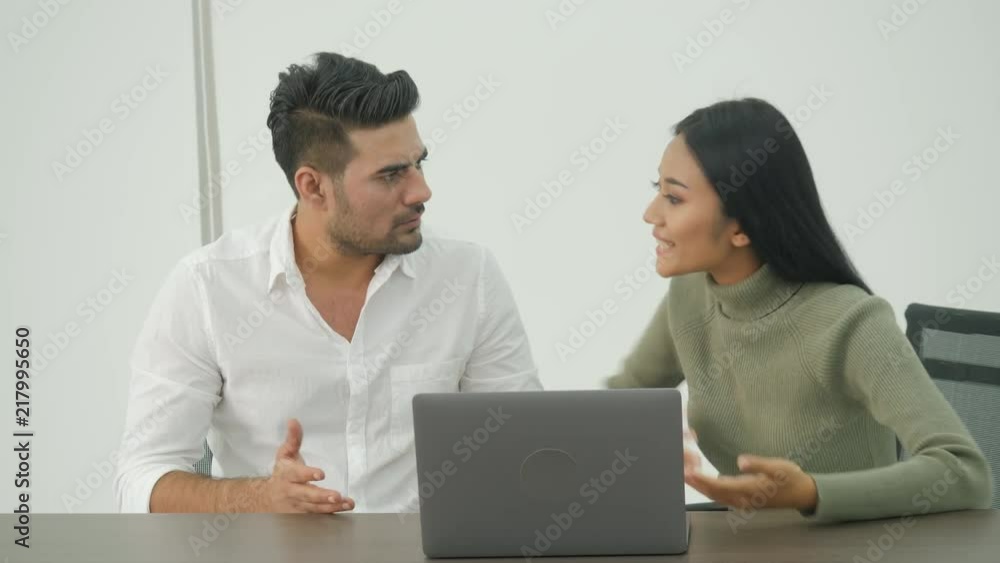Serious stressed business team working on a laptop while discussing a project Serious stressed business team working on a laptop while discussing a project