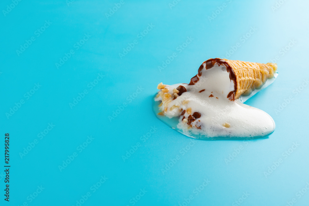 mini Vanilla flavor ice cream cone in a melting process on blue
