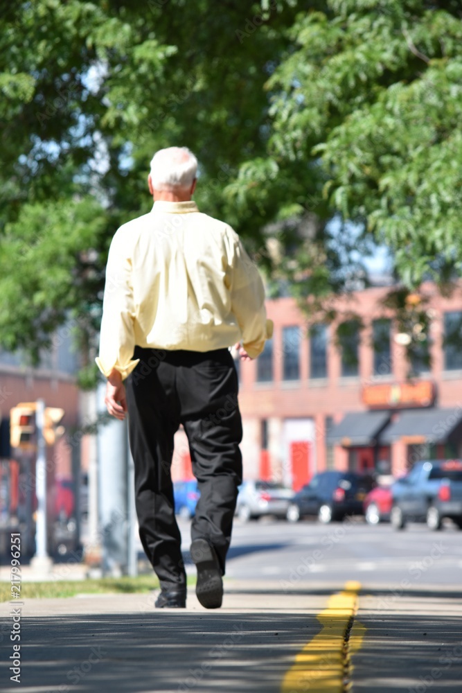 Senior Balding Male Walking On Sidewalk Senior Balding Male Walking On Sidewalk