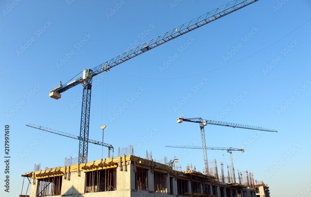 Large construction site including several cranes working on a building complex
