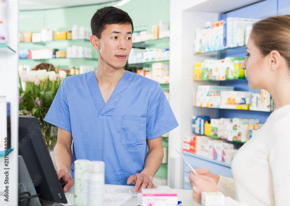 Happy woman is asking pharmacist about medicines