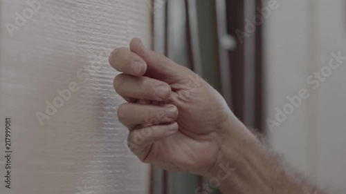 Man's hand knock on a white door