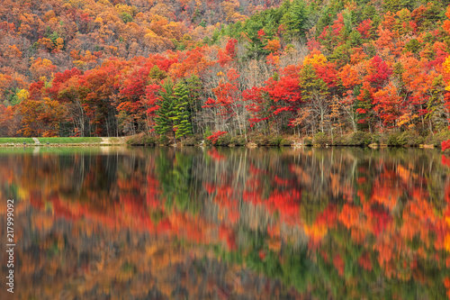 Vibrant autumn scene & water reflections along Sherando Lake within the George Washington National Forest near Lyndhurst, Virginia (USA).