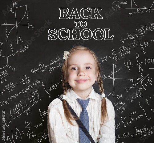Back to school concept. Happy schoolgirl child on chalkboard background with scientific formulas