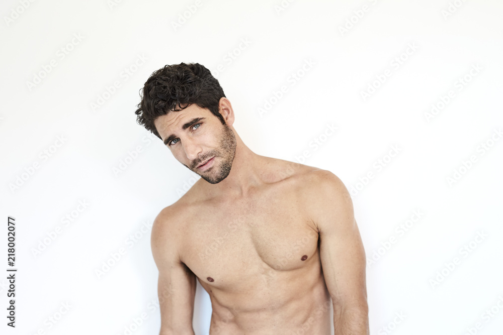 Fototapeta premium Portrait of hunky guy looking at camera, studio