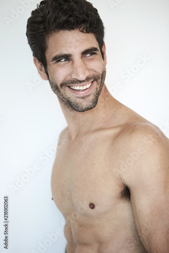 Stubble hunky guy looking over shoulder, smiling