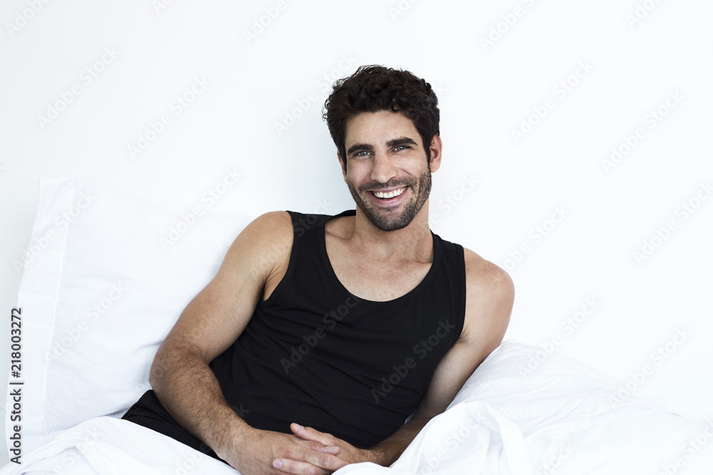 Happy guy in morning relaxing in bed Happy guy in morning relaxing in bed