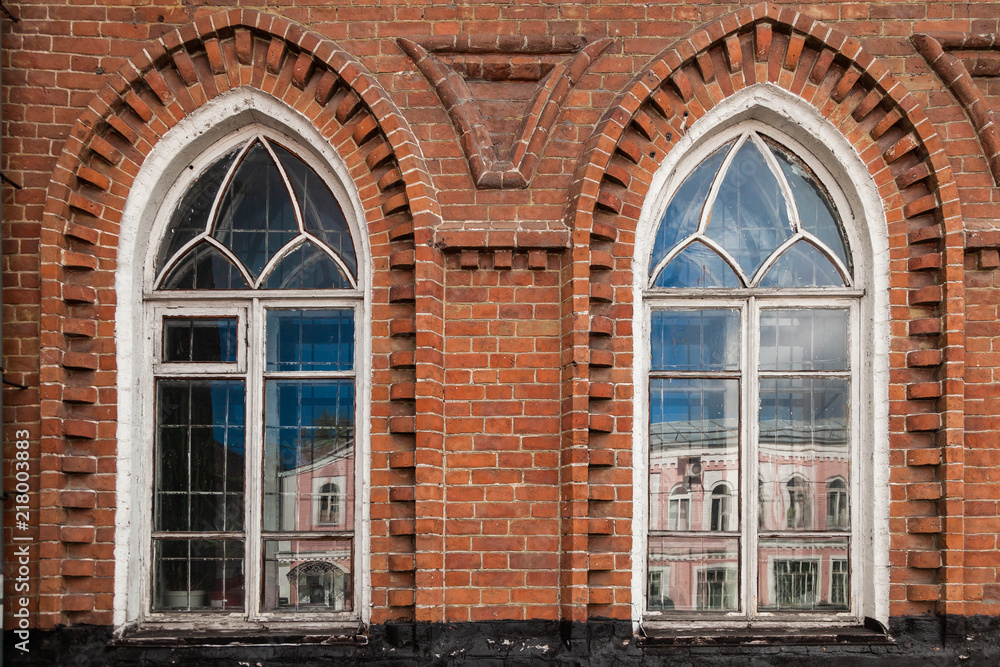 Close-up of a two old windows in old house a mansion made of old brick Close-up of a two old windows in old house a mansion made of old brick